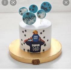 a white cake with blue frosting and some decorations on the top that says dad