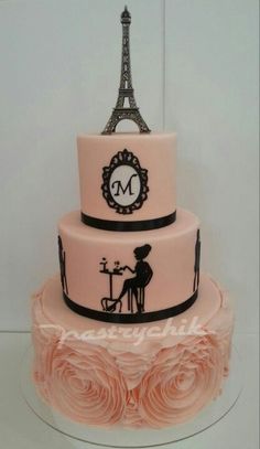 a pink and black cake with the eiffel tower in the background