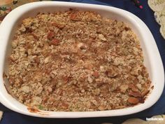 a casserole dish with meat and vegetables in it on a blue table cloth