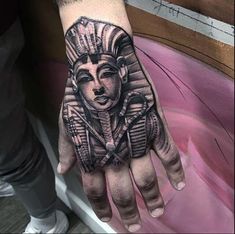 a man's hand with an egyptian tattoo on it