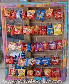 a display case filled with lots of different flavored candy bars and snacks hanging from it's sides