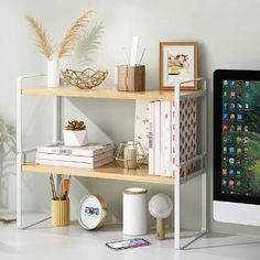 a computer monitor sitting on top of a wooden shelf next to a keyboard and mouse