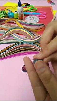 someone is doing something with colored paper and scissors