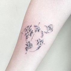 a woman's arm with flowers on it and the letter q in black ink