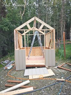 an unfinished shed with the door open and some tools laying around on the ground in front of it