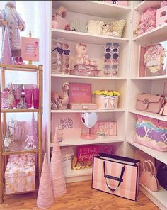 a room filled with lots of pink and white items on shelves next to a window