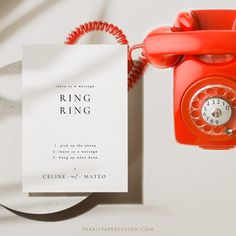 an orange phone next to a white card with the words ring ring on it and a red telephone