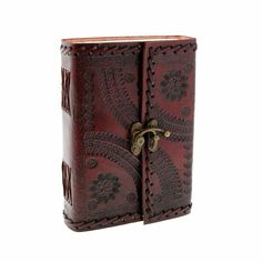 a handmade leather journal with an intricate design on the front and side, is shown