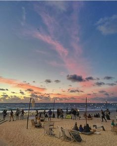 many people are on the beach at sunset or sunrise time, and there is no image here to provide a caption for