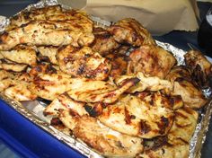 grilled chicken on tin foil in a blue container