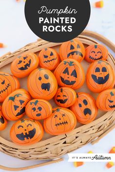 a basket filled with orange pumpkins sitting on top of a white table next to candy