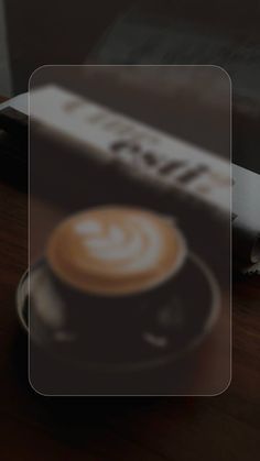 a cup of coffee sitting on top of a wooden table