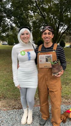 a man and woman dressed up in costumes standing next to each other with a dog