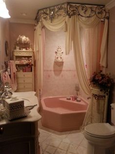 a pink bath tub sitting next to a toilet in a bathroom