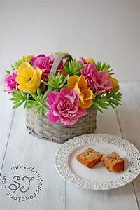 a basket filled with flowers next to two slices of cake on a plate and another piece of bread