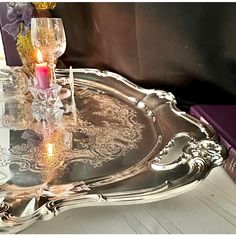 a silver tray with two candles on it