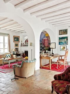 a living room filled with lots of furniture next to a fire place and windows on the wall