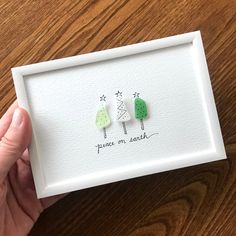 a person holding up a card with two trees on it