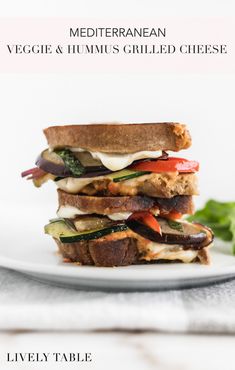 a stack of grilled cheese sandwiches on a plate with lettuce and tomato