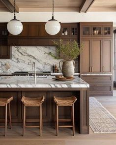 a large kitchen with marble counter tops and wooden stools in front of an island