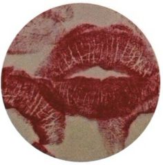 a red and white photo of two lips on a circular surface with the word kiss written across it