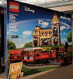 an advertisement for legos is displayed on the wall in front of a train station