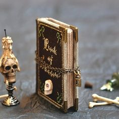 there is a small book with skulls and bones on the table next to it, as well as a skeleton figurine