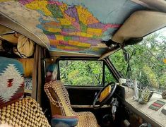 the interior of an old car is decorated with colorful rugs and other decorative items