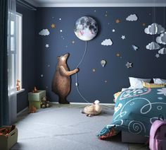 a child's bedroom decorated in blue and white with a bear holding a balloon