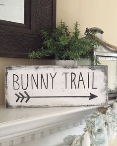 a wooden sign that says bunny trail with an arrow pointing to the right on a mantle