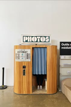 a photo booth with blue curtains and a sign on top