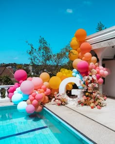 an outdoor pool decorated with balloons and flowers