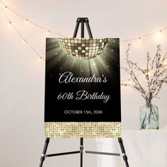 a black and white sign with lights around it on a easel next to a vase