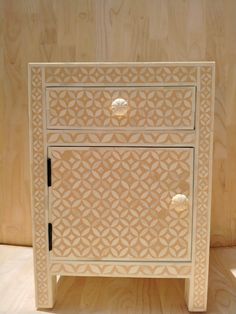 an intricately carved wooden cabinet with two drawers on the bottom and one drawer open