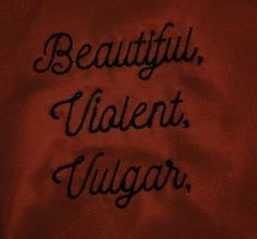 the words are written in black ink on a red cloth with an embroidered design that reads, beautiful, violent, yugar