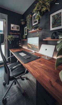 a desk with a laptop computer on top of it next to a potted plant