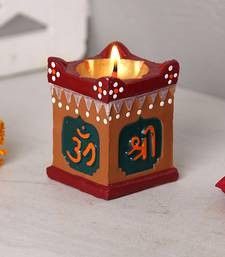 a small candle holder sitting on top of a white table next to some orange and red decorations