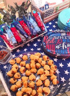 an american flag table with snacks on it and plates full of candy in the shape of stars