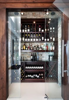 a wine cellar with glass doors and shelves filled with bottles