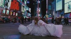 a woman in a white dress is walking down the street