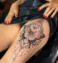 a woman's thigh with a butterfly tattoo on it