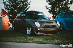 two cars parked next to each other in the grass