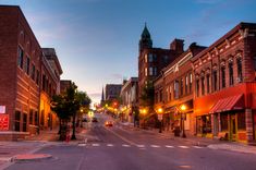 an empty city street at dusk with buildings on both sides