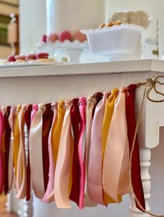 ribbons are hanging from a table with cupcakes on it