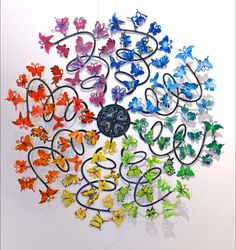 a group of butterflies that are connected to a clock on a wall hanging from the ceiling