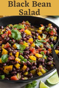 a black bean salad with cilantro, peppers, and limes in a skillet