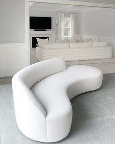 a large white couch sitting in the middle of a living room next to a fireplace