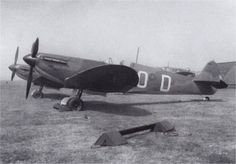 an old airplane sitting on top of a grass covered field next to another plane in the background