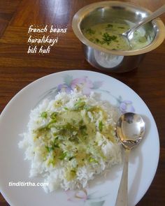 a white plate topped with rice and broccoli next to a silver bowl filled with soup