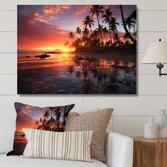 a living room with a couch, table and pictures on the wall above it at sunset